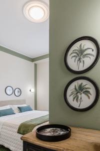 - une chambre avec un lit et deux palmiers sur le mur dans l'établissement Appartamento Vert, à Diano Marina