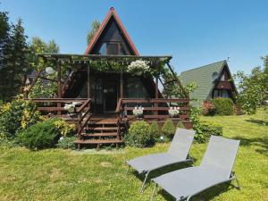 a cabin with two chairs in front of it at Domek Letniskowy Dario in Ińsko