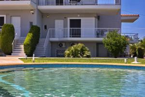 a villa with a swimming pool in front of a house at Family Maisonette with pool #4 in Nea Fokea