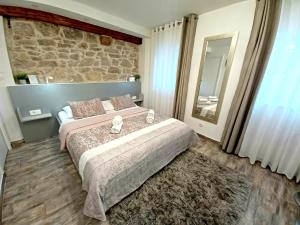 - une chambre avec un grand lit et un mur en pierre dans l'établissement Studio Apartmani Pomalo/ Take It Easy, à Split