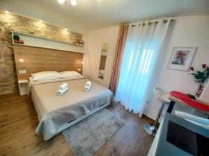 a bedroom with a bed with two towels on it at Studio Apartmani Pomalo/ Take It Easy in Split
