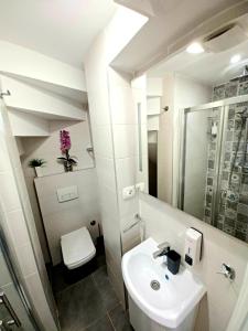 a white bathroom with a sink and a toilet at Studio Apartmani Pomalo/ Take It Easy in Split