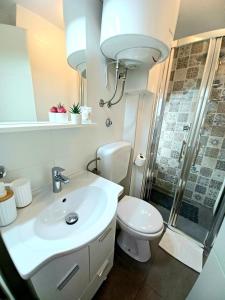 uma casa de banho com um WC, um lavatório e um chuveiro em Studio Apartmani Pomalo/ Take It Easy em Split