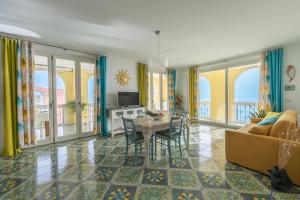 a living room with a table and chairs and a couch at DOLF - Attico sul Mare in Porto Recanati