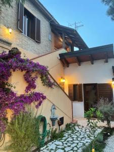 a house with purple flowers on the side of it at Casa Drema - Villa al mare con terrazza in Pescara