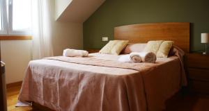 a bedroom with a large bed with two stuffed animals on it at Apartamentos Gallaecia in Val do Dubra