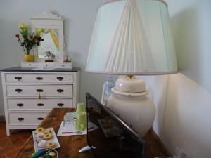 una lampada seduta su un tavolo accanto a un comò di Il Nido della Formica a Colonnata