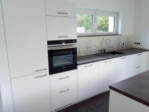 una cocina blanca con armarios blancos y fregadero en Several different rooms, newly furnished, in a new house in Vichten, en Vichten