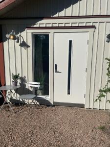 un garage blanc avec une porte sur le côté de la maison dans l'établissement Hallonet, à Alingsås