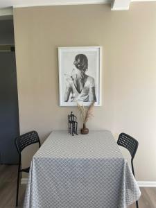 a table with a black and white picture on the wall at Hallonet in Alingsås