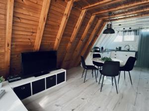 a kitchen and dining room with a table and chairs at Domek Letniskowy Dario in Ińsko