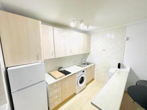 een keuken met een witte koelkast en een wasmachine bij Pretty Penthouse with Prívate terrace in Polop