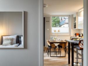 a kitchen and dining room with a table and a window at Vincent Apartamenty Darłówek in Darłowo +31 photos