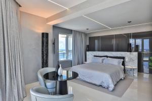 a bedroom with a bed and a table and a chair at Serenity Penthouse - The Pinnacle of Luxury in Maho Reef
