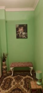 a green room with a bench with a picture on the wall at Apartmani "M" br3 in Topola