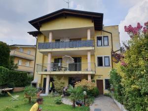 a man standing in front of a yellow house at Desenzano Luxury Apartment in Desenzano del Garda