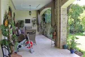 un patio con una moto en una habitación con plantas en Magnifique villa avec piscine pour famille uniquement, en Marrakech