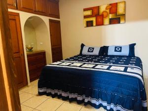 a bedroom with a bed with blue and white sheets at Casa en Los Cabos, 3 recámaras in Cabo San Lucas