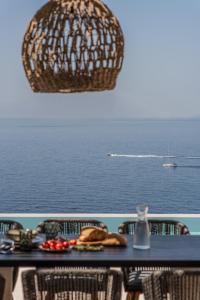 a table with a view of the ocean and a boat at Limnionas Infinity Cave Villa in Kampíon