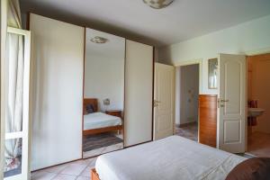 1 dormitorio con paredes blancas y 1 cama con espejo en Free parking-Animal Friendly- Rainbow MagicLand, en Lariano