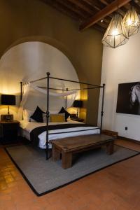 a bedroom with a canopy bed and a wooden table at Hacienda El Salitre Hotel & Spa in Querétaro