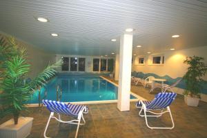 une piscine avec deux chaises et une table dans l'établissement HP Touristik - Seepark Burhave 7, à Butjadingen