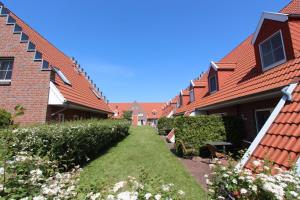 une rangée de maisons avec une pelouse dans la cour dans l'établissement HP Touristik - Seepark Burhave 7, à Butjadingen