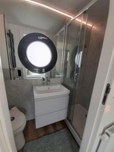La salle de bains est pourvue de toilettes, d'un lavabo et d'une fenêtre. dans l'établissement Hausboot Aava, à Schleswig