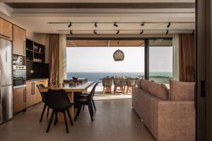 a kitchen and dining room with a view of the ocean at Limnionas Serenity Cave Villa in Kampion