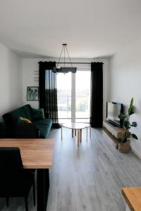 uma sala de estar com um sofá e uma mesa em Apartament Tramwajowa 17B em Lódź