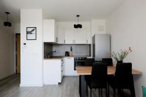 a kitchen and dining room with a table and chairs at Apartament Tramwajowa 17B in Łódź