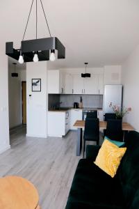a living room and kitchen with a couch and a table at Apartament Tramwajowa 17B in Łódź