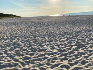 una playa de arena con huellas en la arena en Karwia-Karwieńskie Błota domek przy plaży en Karwieńskie Błoto Drugie