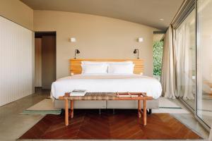 a bedroom with a large bed and a wooden headboard at Immerso Hotel, a Member of Design Hotels in Ericeira