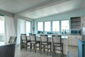 a kitchen with a bar with chairs and a table at Happy Days Villa B in Fajardo