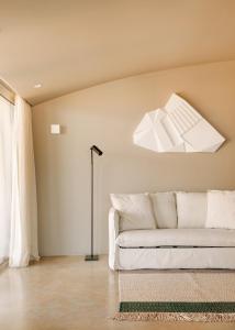 a living room with a white couch and a chandelier at Immerso Hotel, a Member of Design Hotels in Ericeira