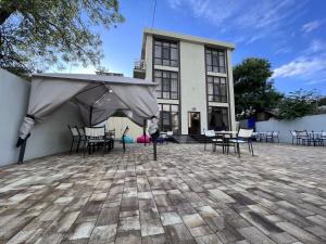 a building with tables and chairs in front of it at Moon Hotel in Gelendzhik