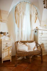 een kamer met een rieten stoel en een raam bij Casa Dolce Casa in Martina Franca