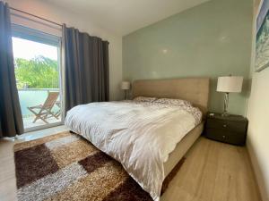 a bedroom with a bed and a window with a patio at Prime 1 Bedroom Condo in Historic Downtown Playa del Carmen in Playa del Carmen +19 photos