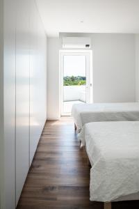 - une chambre avec 2 lits et une fenêtre dans l'établissement Casa Monte dos Entrudos, à Almancil