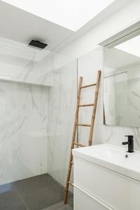 een badkamer met een ladder naast een wastafel bij Casa Monte dos Entrudos in Almancil