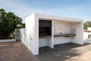 a white building with a kitchen on a patio at Casa Monte dos Entrudos in Almancil