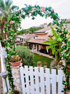 a white picket fence with a arch with pink roses at Favola Exclusive b&b in Pescara