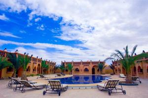 a courtyard with chairs and a swimming pool at Residence Touristique Merzouga in Merzouga