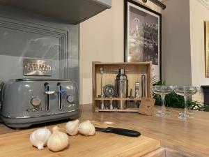 a kitchen with garlic on a cutting board and a knife at Cosy Open Plan Harbourside Inn with SuperKing Beds, Wood Burning Stove and Bar in Torquay