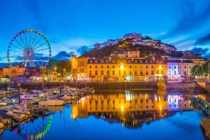 a city with a ferris wheel and boats in the water at Cosy Open Plan Harbourside Inn with SuperKing Beds, Wood Burning Stove and Bar in Torquay