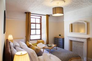 a living room with a couch and a fireplace at Cosy Open Plan Harbourside Inn with SuperKing Beds, Wood Burning Stove and Bar in Torquay