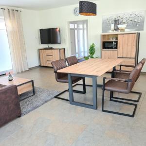 a living room with a wooden table and chairs at Haus Hobbingshof Greetsiel in Greetsiel