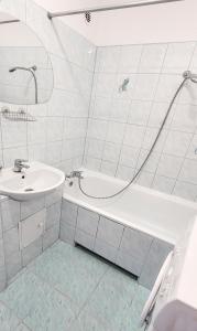 uma casa de banho branca com uma banheira e um lavatório em Apartament Fileo em Koszalin