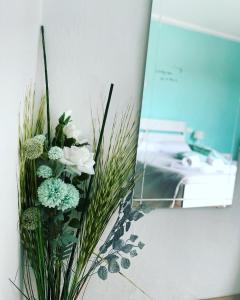 a vase filled with white and green flowers on a wall at Il nido di Tiffany in Massino Visconti